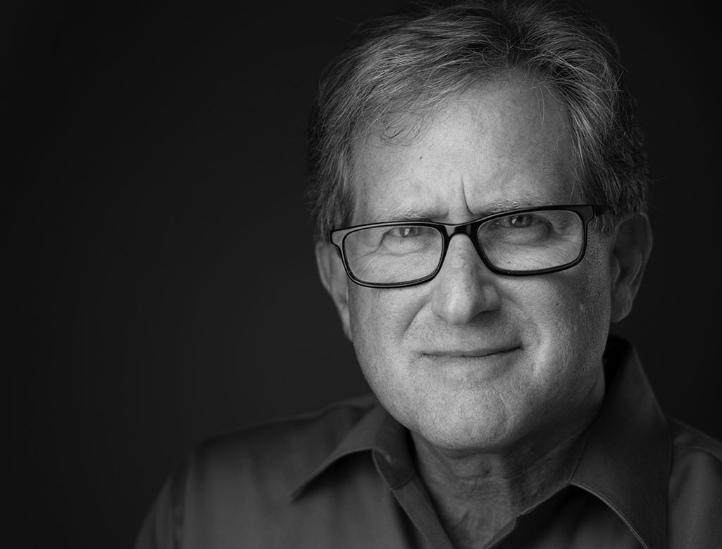 Headshot of Gary Walens a middle age caucasian with glasses, graying ahri, wearing dark colored button down shirt.